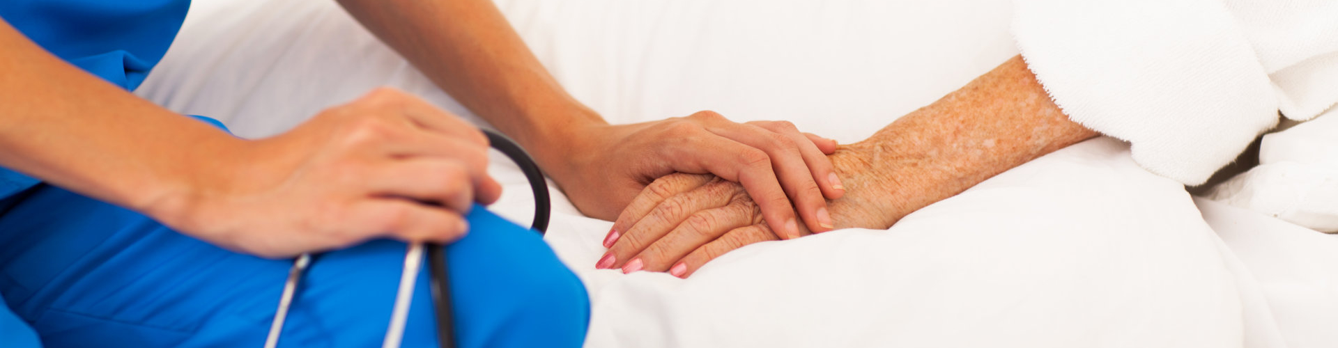 nurse holding senior patient's hands